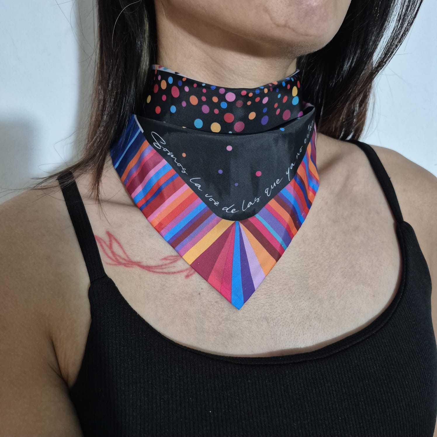 Pañuelo usado al cuello con frase y franjas de color